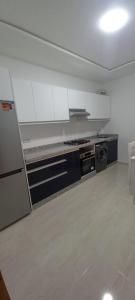 a kitchen with white cabinets and a stove top oven at Yaacob & Adam apartment Riad Sofia Martil in Martil +16 photos
