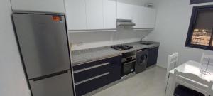 a kitchen with a refrigerator and a stove top oven at Yaacob & Adam apartment Riad Sofia Martil in Martil