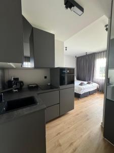 a kitchen with stainless steel appliances and a bedroom at Garden Apartments in Berlin