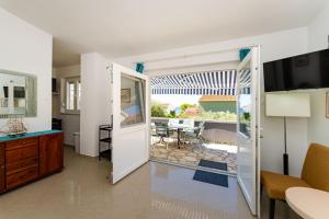 a living room with a door leading to a patio at Apartments Crnko, 50m from the beach with free parking and drinkable tap water in Vir