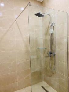 una ducha con puerta de cristal en un baño en Gonio Family inn, en Gonio