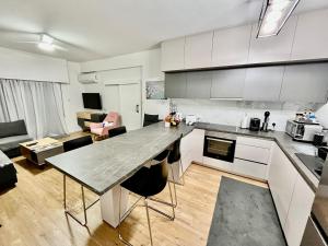 a kitchen and living room with a large counter top at Modern apartment near McKenzie beach in Larnaca