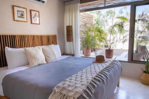 a bedroom with a large bed and a large window at Samiik by Arkylab in Tulum +175 photos