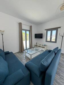 a living room with a blue couch and a table at Marielen House in Kampos Paros