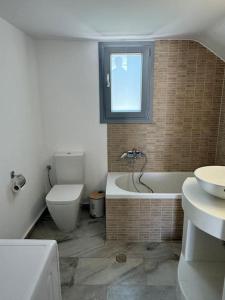 a bathroom with a tub and a toilet and a sink at Marielen House in Kampos Paros