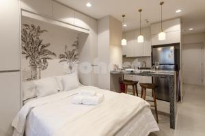 a bedroom with a white bed and a kitchen at Brand New Loft Near Paseo La Galeria in Asuncion +25 photos