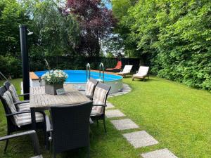a table and chairs next to a swimming pool at AP-Ranch Ferienzimmer Auszeit in Astätt