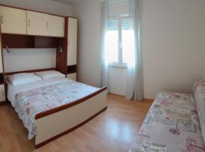a bedroom with a large bed and a window at Apartments Oaza Regi in Medulin