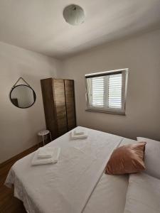 a bedroom with a large white bed with a mirror at Klara in Vodice