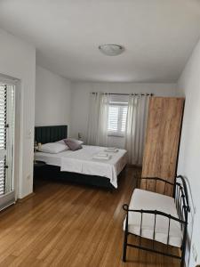 a bedroom with a bed and a chair in it at Klara in Vodice