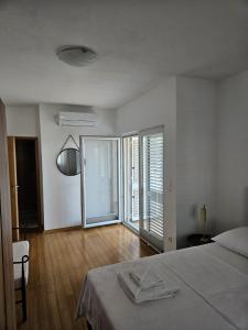 a white room with a bed and a large window at Klara in Vodice