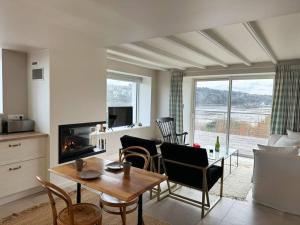 a living room with a table and chairs and a fireplace at Ker Agak Maison vue mer panoramique pour 7 pers in Plougasnou
