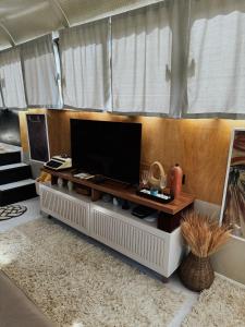 Una sala de estar con un televisor de pantalla plana sobre una mesa. en Hosperdagem no Ônibus Off White em Santa Teresa no Circuito Caravaggio, en Santa Teresa 16 fotos más