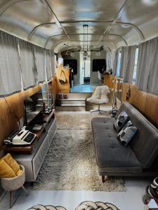 sala de estar con sofá y mesa en un autobús en Hosperdagem no Ônibus Off White em Santa Teresa no Circuito Caravaggio, en Santa Teresa