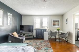 a living room with a tv and a table and chairs at Modern Apartment on James St South in Hamilton +7 photos