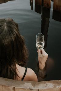 a woman holding a glass of wine in the water at Somoskabin in Salgótarján +12 photos