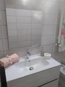 ein Badezimmer mit einem weißen Waschbecken und einem Spiegel in der Unterkunft Casa Ester in Ascea