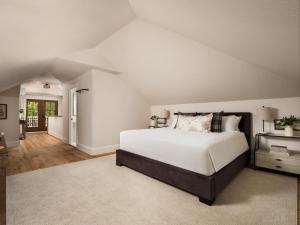 a bedroom with a large white bed and a hallway at 1313 West Luxury Boutique Hotel in Annapolis