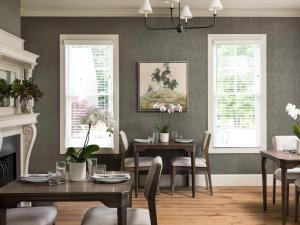 a dining room with tables and chairs and windows at 1313 West Luxury Boutique Hotel in Annapolis