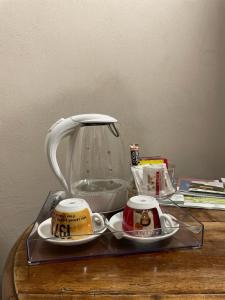 a tea kettle and two cups on a table at Asfodelo rooms in Bra +24 photos