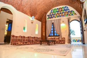 a living room with a bench and stained glass windows at Elmamora tunis in Kafr ‘Amr