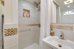 a white bathroom with a shower and a sink at Cozy and Convenient Elmont Retreat with Patio! in Elmont