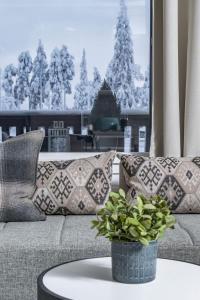 un divano con cuscini e un tavolo con una pianta di Ruka Chalets 3 huoneisto 3202 a Kuusamo