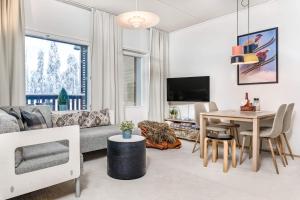 un soggiorno con un divano e un tavolo di Ruka Chalets 3 huoneisto 3202 a Kuusamo Altre 8 foto