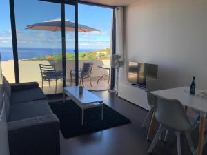 a living room with a couch and a view of the ocean at Villa Pinheira I in Calheta