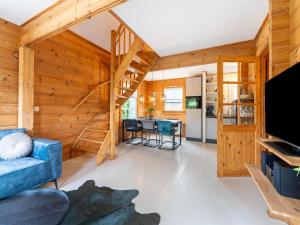 a living room with wooden walls and a spiral staircase at Holiday Home by Zuidlaardermeer with Jetty in Groningen