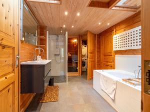 a bathroom with a tub and a shower and a sink at Holiday Home by Zuidlaardermeer with Jetty in Groningen +32 photos