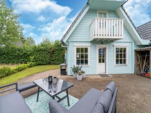 a patio in front of a blue house at Holiday Home by Zuidlaardermeer with Jetty in Groningen