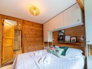 a bedroom with a large white bed with wooden walls at Holiday Home by Zuidlaardermeer with Jetty in Groningen