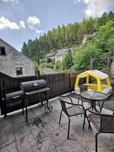 a patio with a grill and a table and chairs at Apartmány Cipriani in Jáchymov