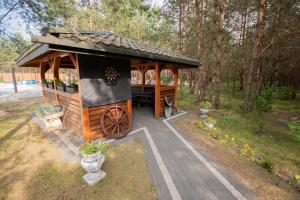 a gazebo with a wheel in a park at Domki całoroczne Koczalski Chillout KASZUBY in Koczała