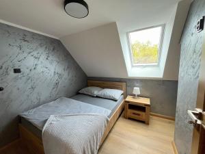Un dormitorio pequeño con una cama y una ventana. en Domki całoroczne Koczalski Chillout KASZUBY, en Koczała 68 fotos más