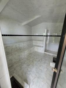 a bathroom with a shower and a tile floor at Casa Pinilla in Ricaurte +6 photos