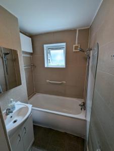 a bathroom with a bath tub and a sink at Central London Rooms N1 6RJ in London