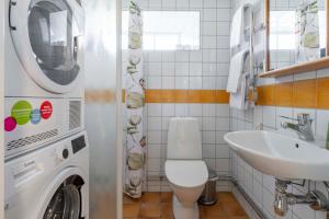 a bathroom with a washing machine and a sink at Charming Garden View Apartment with Terrace & grill in Visby