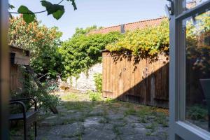 a garden view from the window of a house at Charming Garden View Apartment with Terrace & grill in Visby