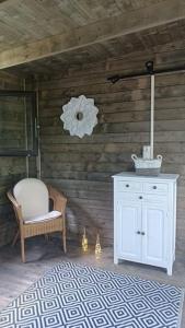 een kamer met een witte kast en een stoel bij Chalet en Ardèche in Fabras