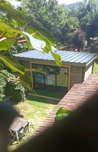 een klein gebouw met een raam en een bank bij Chalet en Ardèche in Fabras