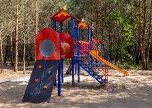 un patio de recreo con un tobogán en un parque en Domki całoroczne Koczalski Chillout KASZUBY, en Koczała