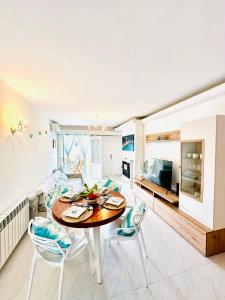 a kitchen and living room with a table and chairs at Bonito apartamento con piscina a 50 metros de la playa! in Port de Pollensa