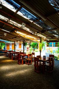 un gruppo di tavoli e sedie in un ristorante di Flutterby House Hostel a Uvita