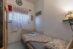 a small bedroom with a bed and a clock on the wall at Cozy Home with Private Garden - Happy Rentals in Dražice