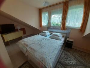 a bedroom with a large bed and a window at Prima Pihenő in Miskolctapolca