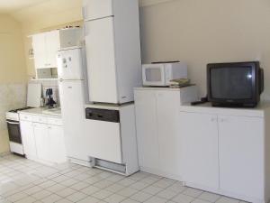 a kitchen with white appliances and a small tv at Prima Pihenő in Miskolctapolca