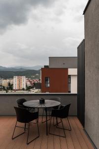 Una mesa y sillas en un balcón con vista. en Skylark - Tokyo Penthouse with Jacuzzi, Movie Theater & Panoramic View, en Brasov