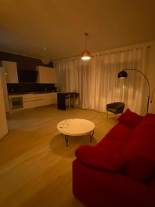 a living room with a red couch and a table at Le Margherite in Montesilvano